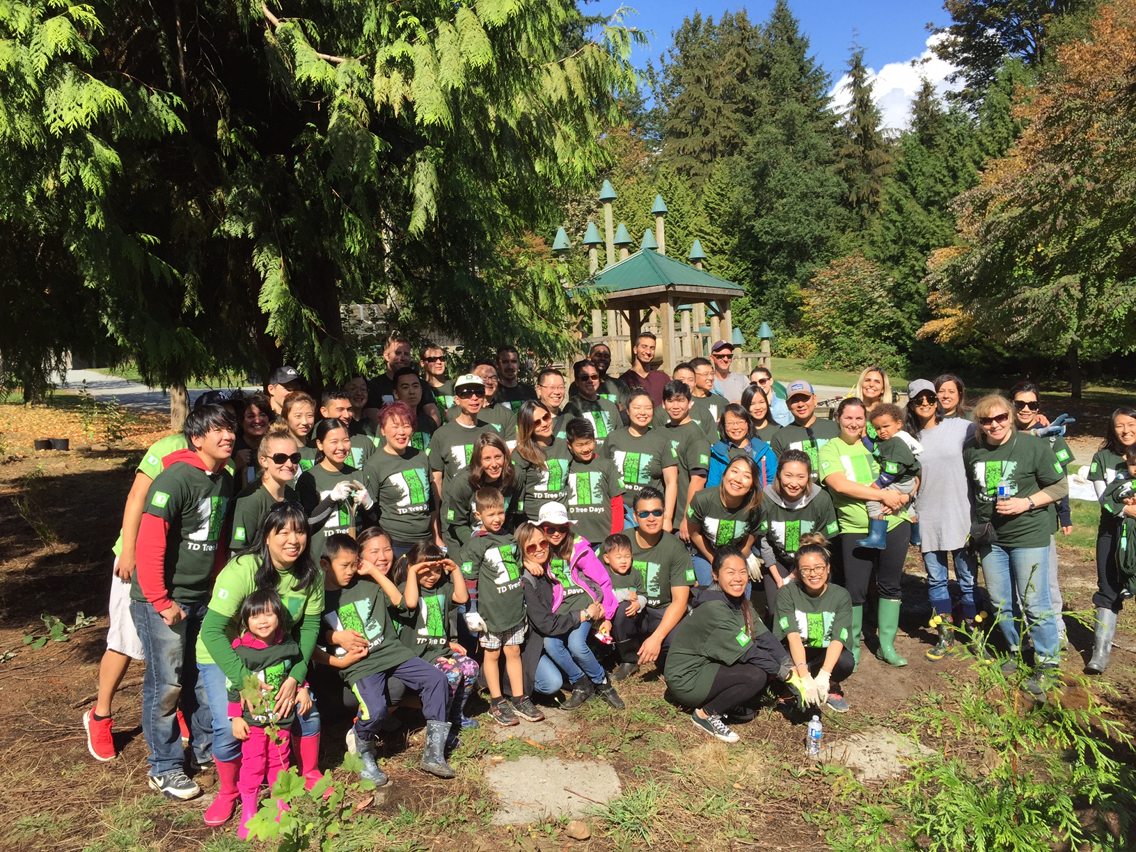 A large group of volunteers posing for a photo at a tree planting event